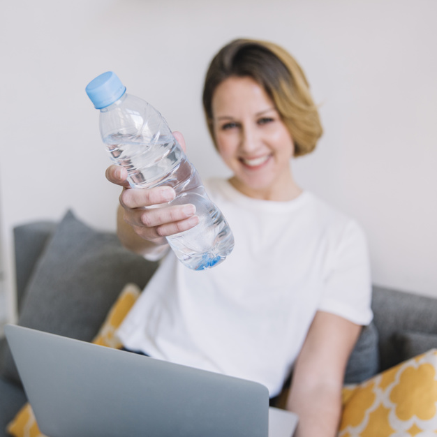 blurred-woman-with-laptop-showing-water-bottle_23-2147765042