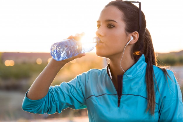 portrait-of-young-woman-drinking-water-after-running_1301-4186