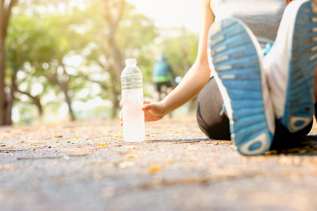 the-fitness-woman-was-sitting-and-picked-up-a-bottle-of-water_38663-42